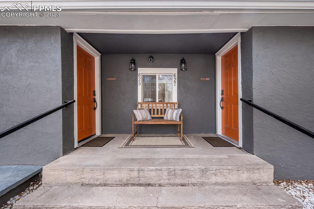 627 Alexander Road Colorado Springs, CO 80909 - Photo 6 of 40 a view of a hallway with wooden floor and a living room