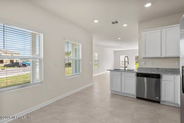 a kitchen with granite countertop white cabinets and white appliances