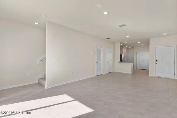 an empty room with a kitchen space and a window