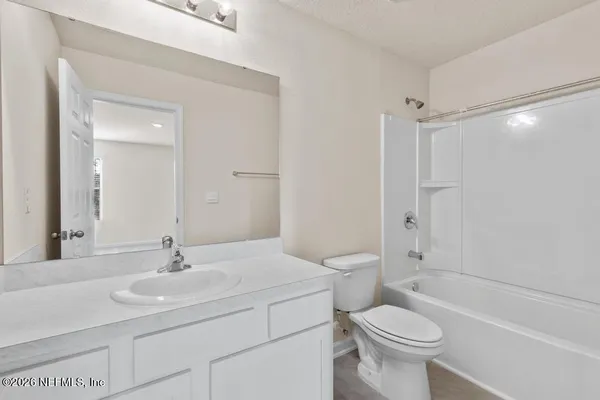 a bathroom with a granite countertop toilet a sink and a mirror