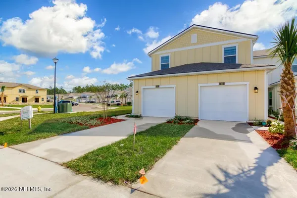a front view of a house with a yard and garage