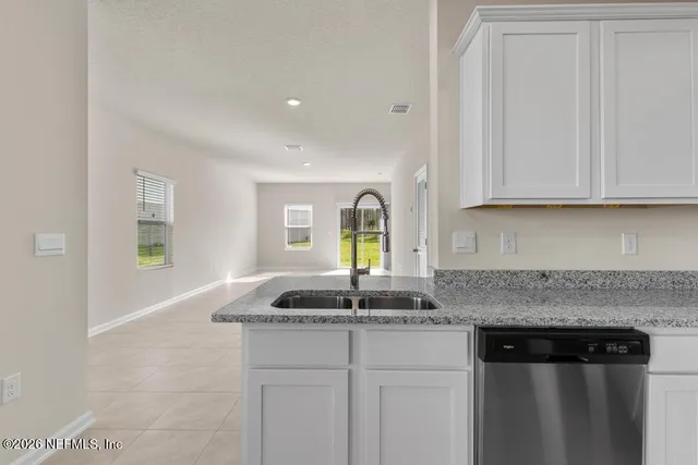 a kitchen with granite countertop a sink and cabinets