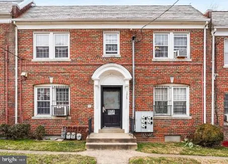 front view of a brick house with a yard