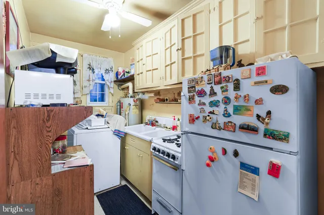 a utility room with fridge and clutter