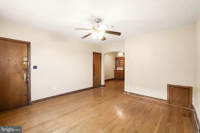 an empty room with closet and a ceiling fan