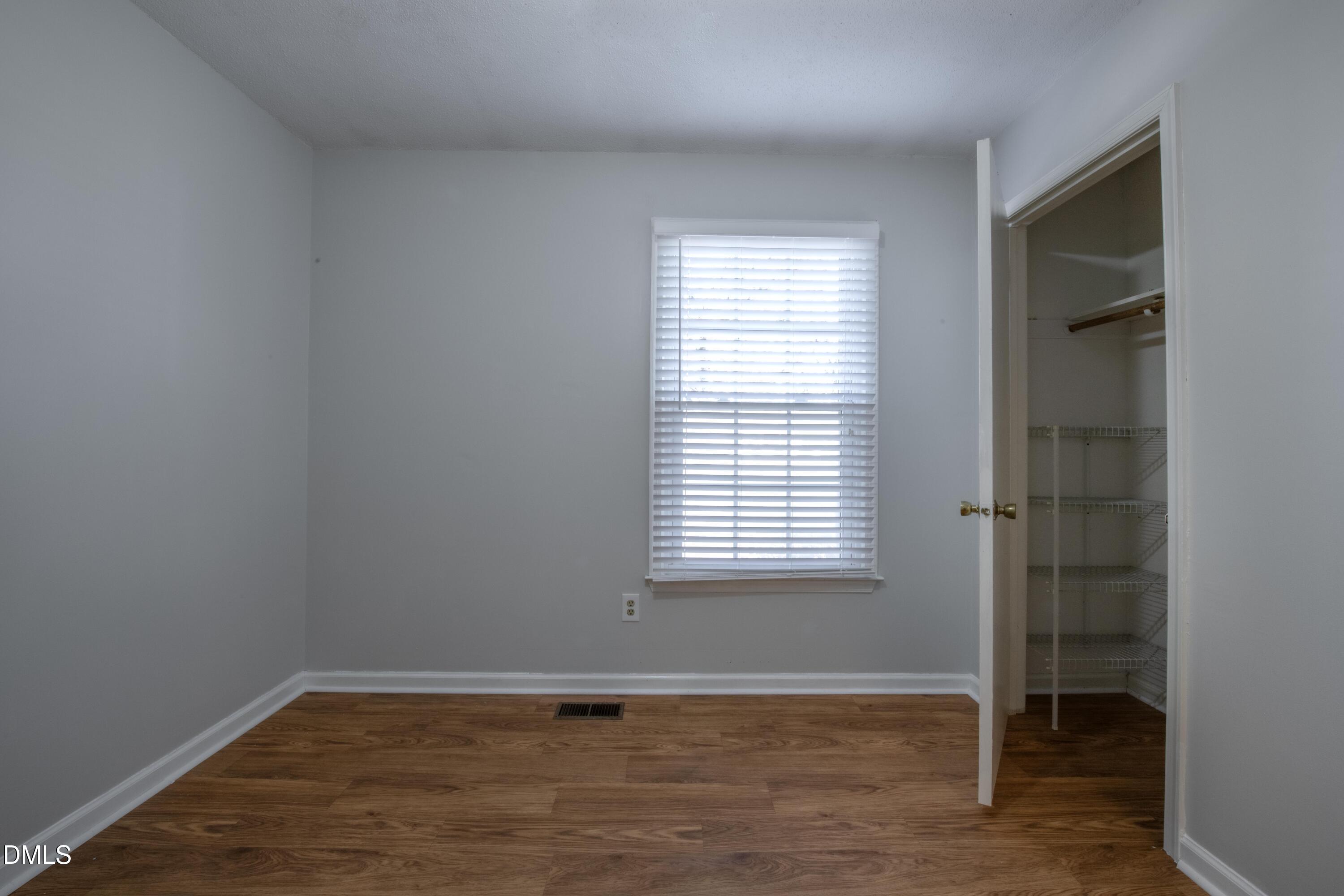 116 East Judd Street Zebulon, NC 27597 - Photo 17 of 21 a view of an empty room with wooden floor and a window