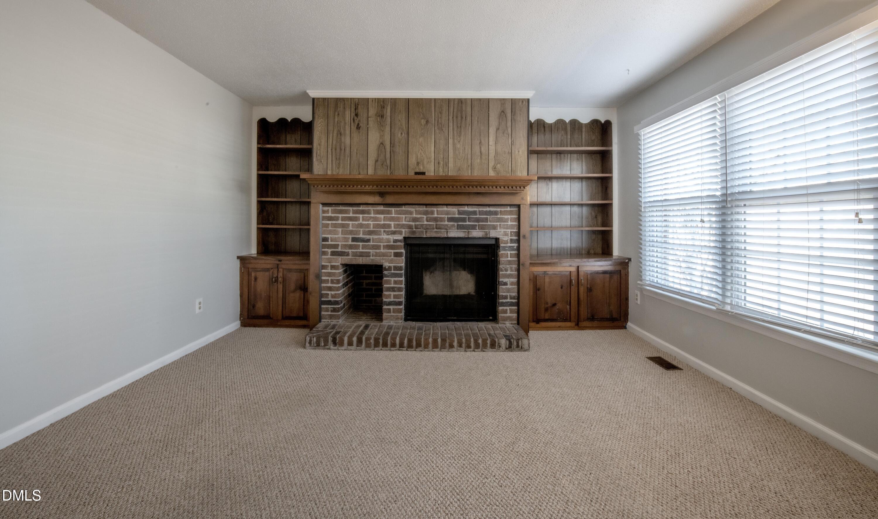 116 East Judd Street Zebulon, NC 27597 - Photo 5 of 21 a view of an empty room with a fireplace and a window