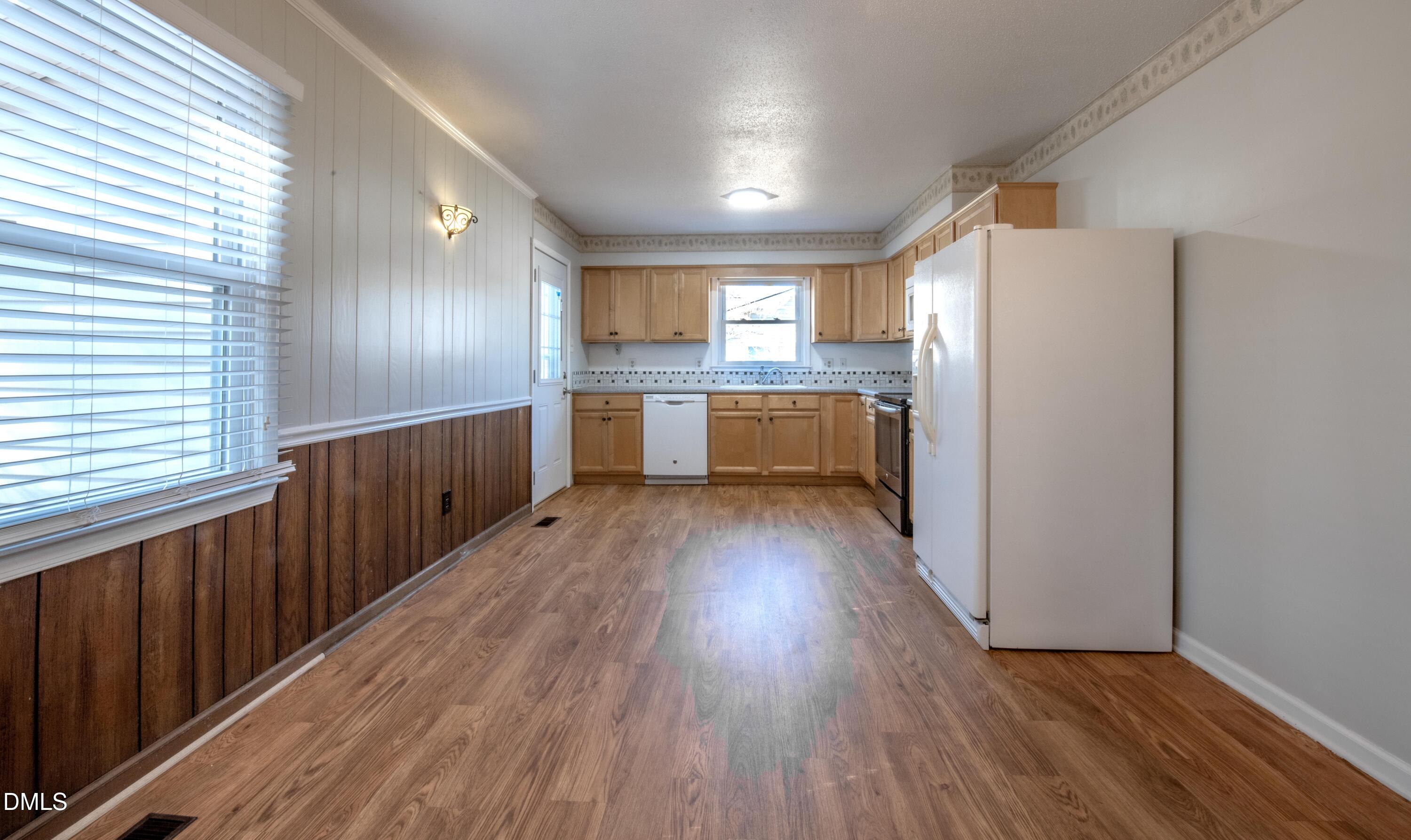 116 East Judd Street Zebulon, NC 27597 - Photo 7 of 21 a kitchen with kitchen island wooden floors appliances and cabinets