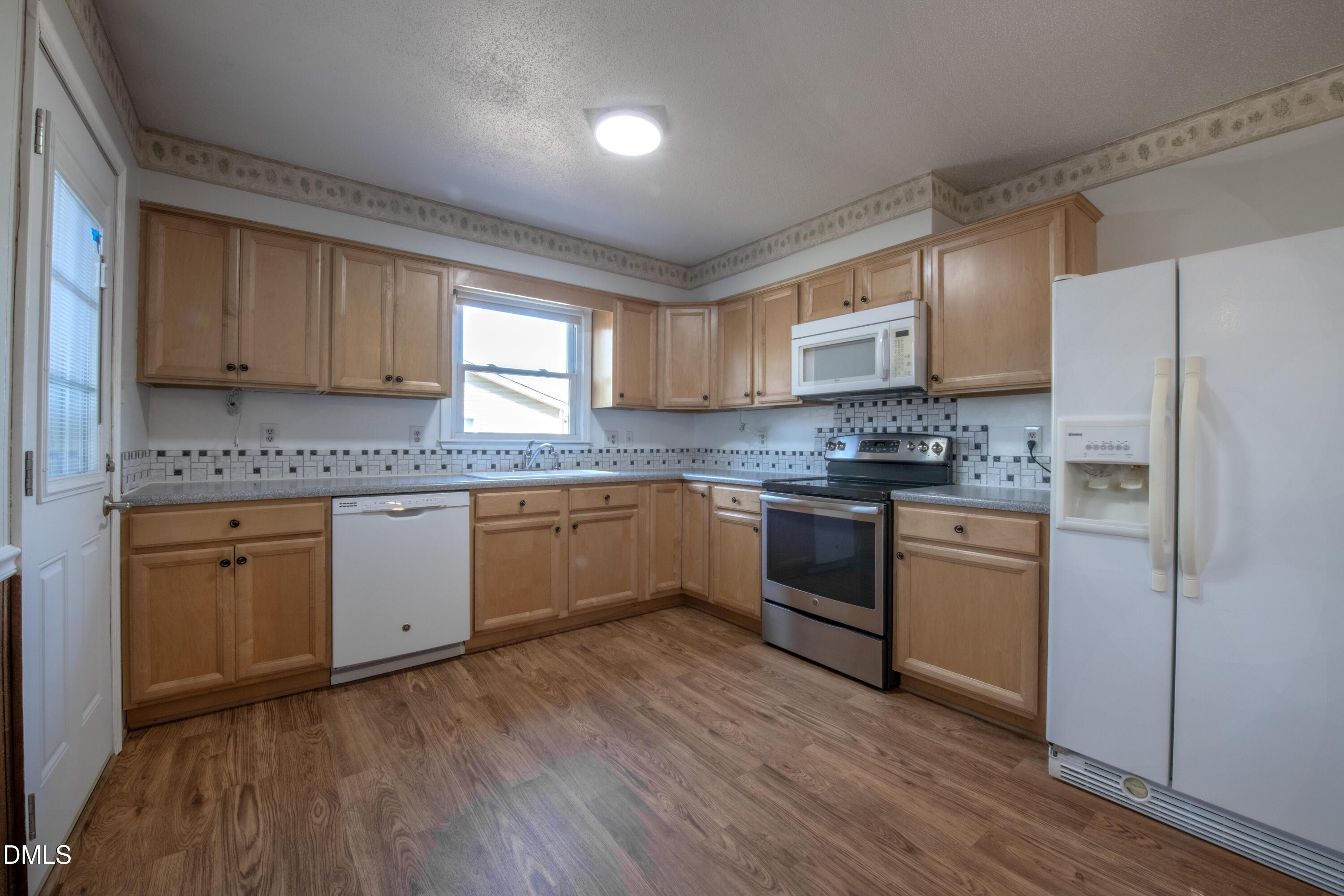 116 East Judd Street Zebulon, NC 27597 - Photo 9 of 21 a kitchen with stainless steel appliances granite countertop a stove a sink dishwasher and a refrigerator