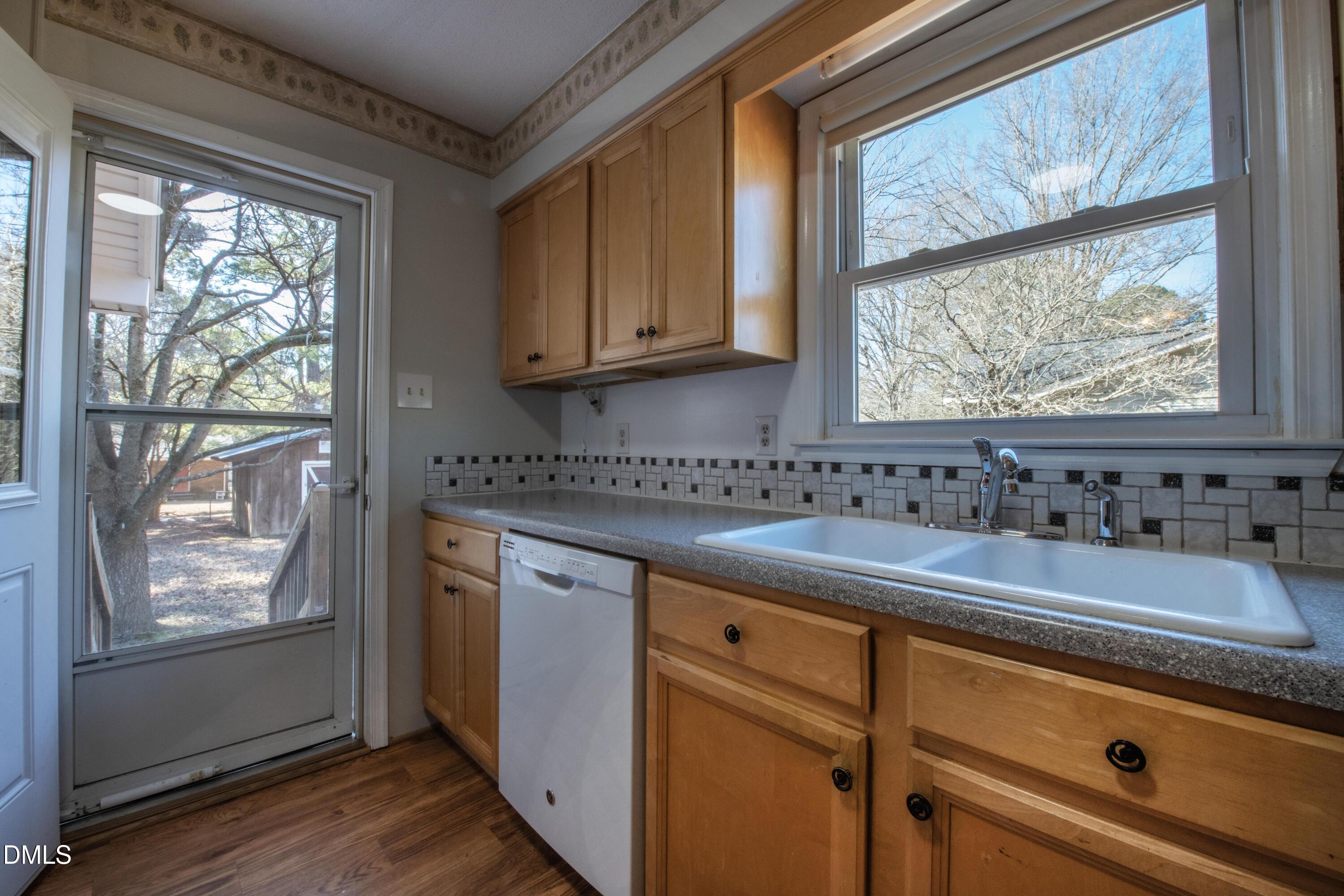 116 East Judd Street Zebulon, NC 27597 - Photo 10 of 21 a kitchen with granite countertop cabinets stainless steel appliances a sink and a window