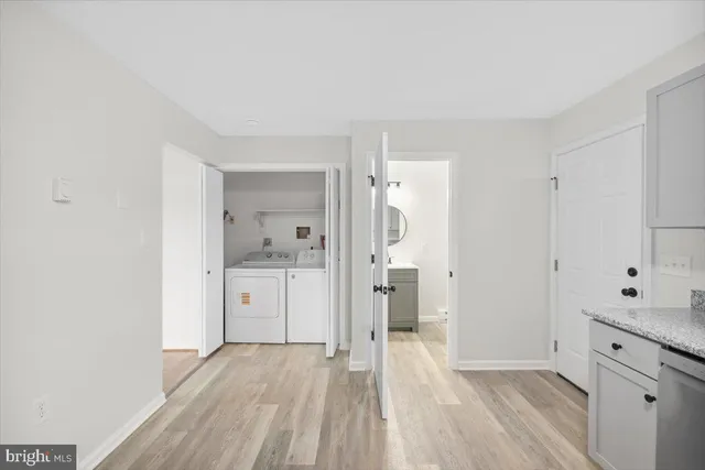 a view of an empty room with closet and wooden floor