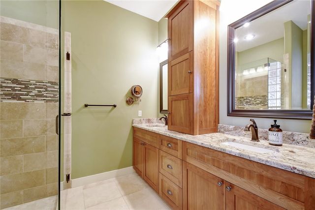 633 Trails End Road Johnson City, TX 78636 - Photo 18 of 29 A spacious vanity with stone countertops highlights this master bathroom design.