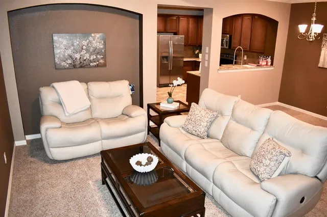 a living room with furniture and painting on the wall