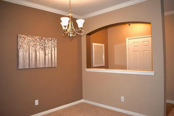 an empty room with windows and chandelier
