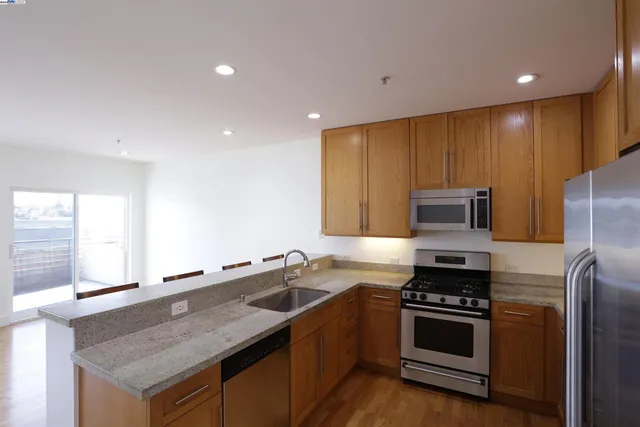 a kitchen with stainless steel appliances granite countertop a stove a sink and a refrigerator