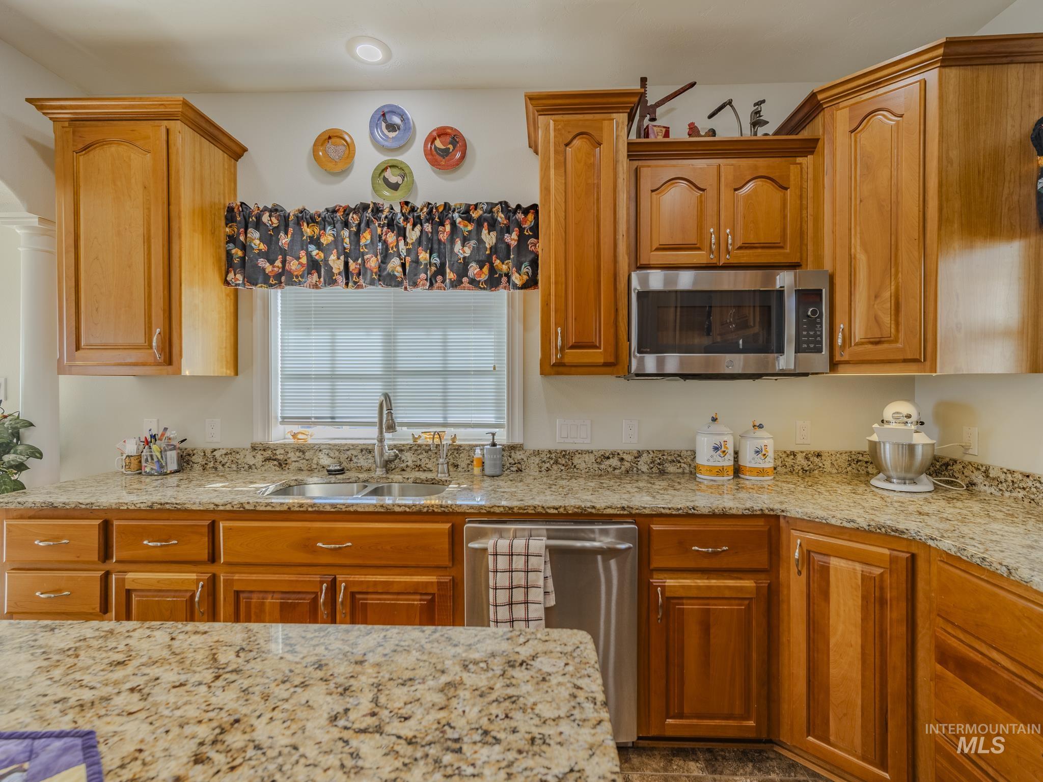 659 Reservation Line Road Cottonwood, ID 83522 - Photo 12 of 50 Kitchen with light stone countertops, stainless steel appliances, and wood finish cabinetry