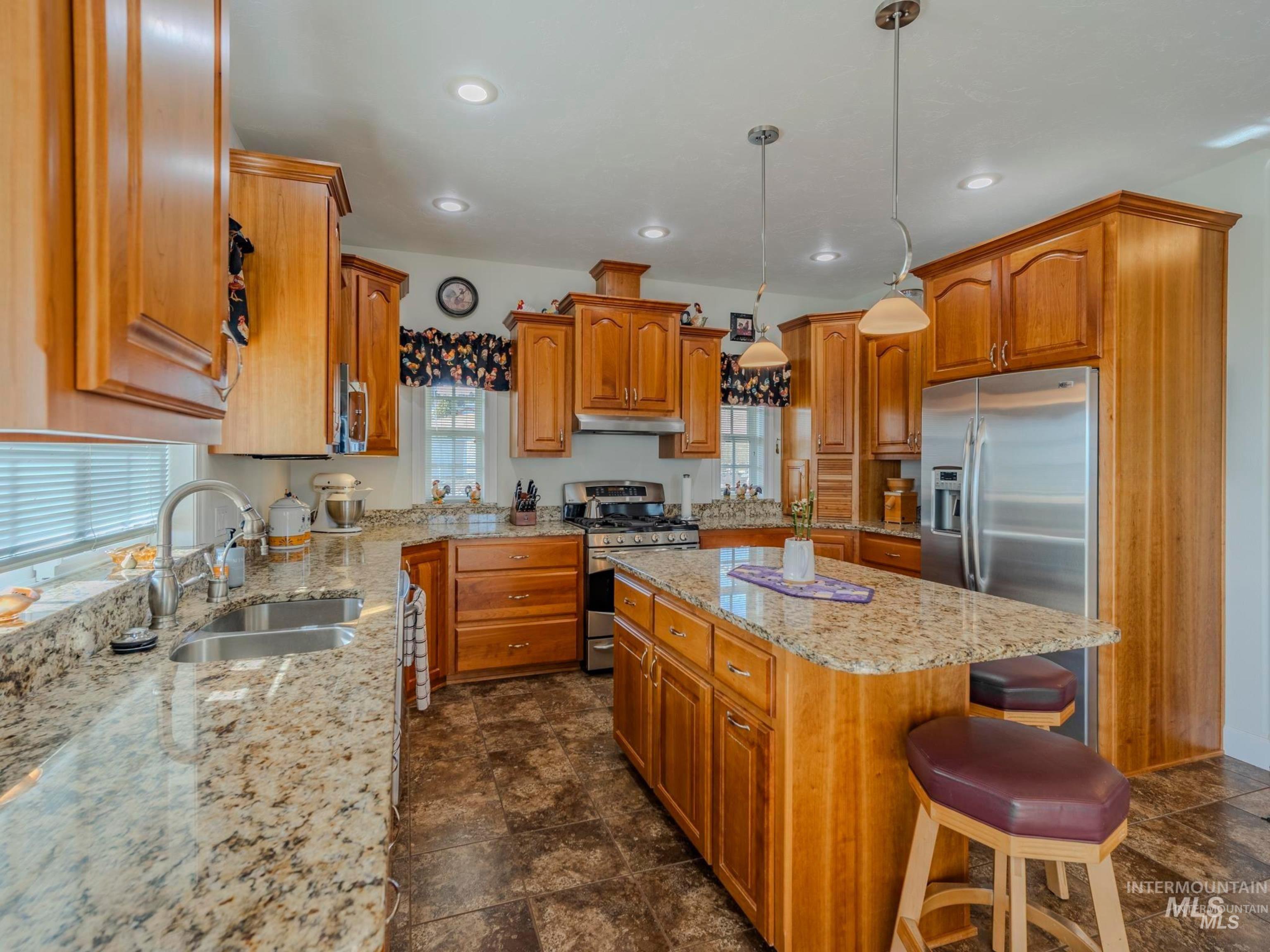 659 Reservation Line Road Cottonwood, ID 83522 - Photo 16 of 50 Kitchen featuring wood finish cabinetry, a breakfast bar area, a center island, and stainless steel appliances