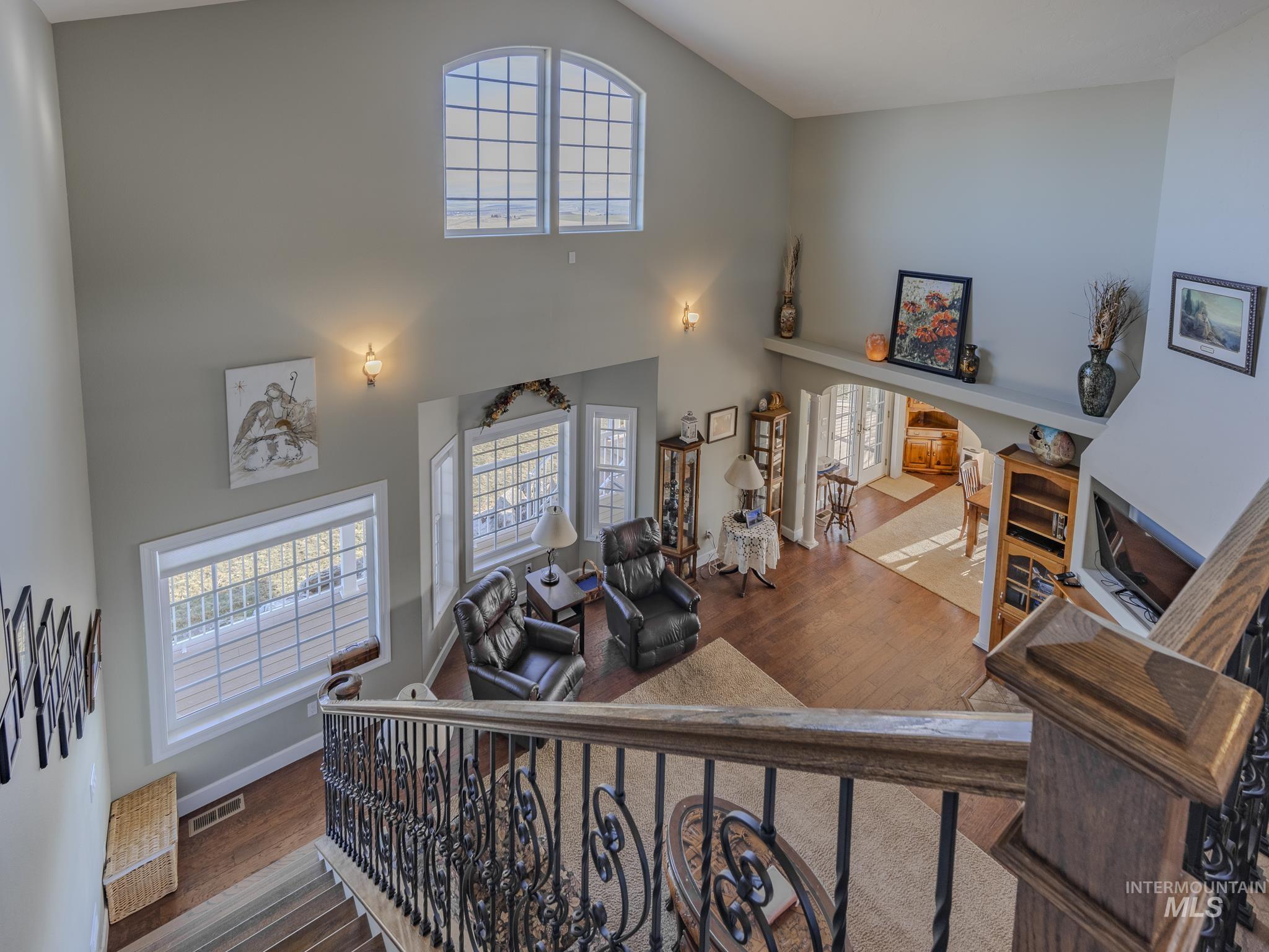 659 Reservation Line Road Cottonwood, ID 83522 - Photo 34 of 50 Stairs featuring arched walkways, wood finished floors, plenty of natural light, and a high ceiling