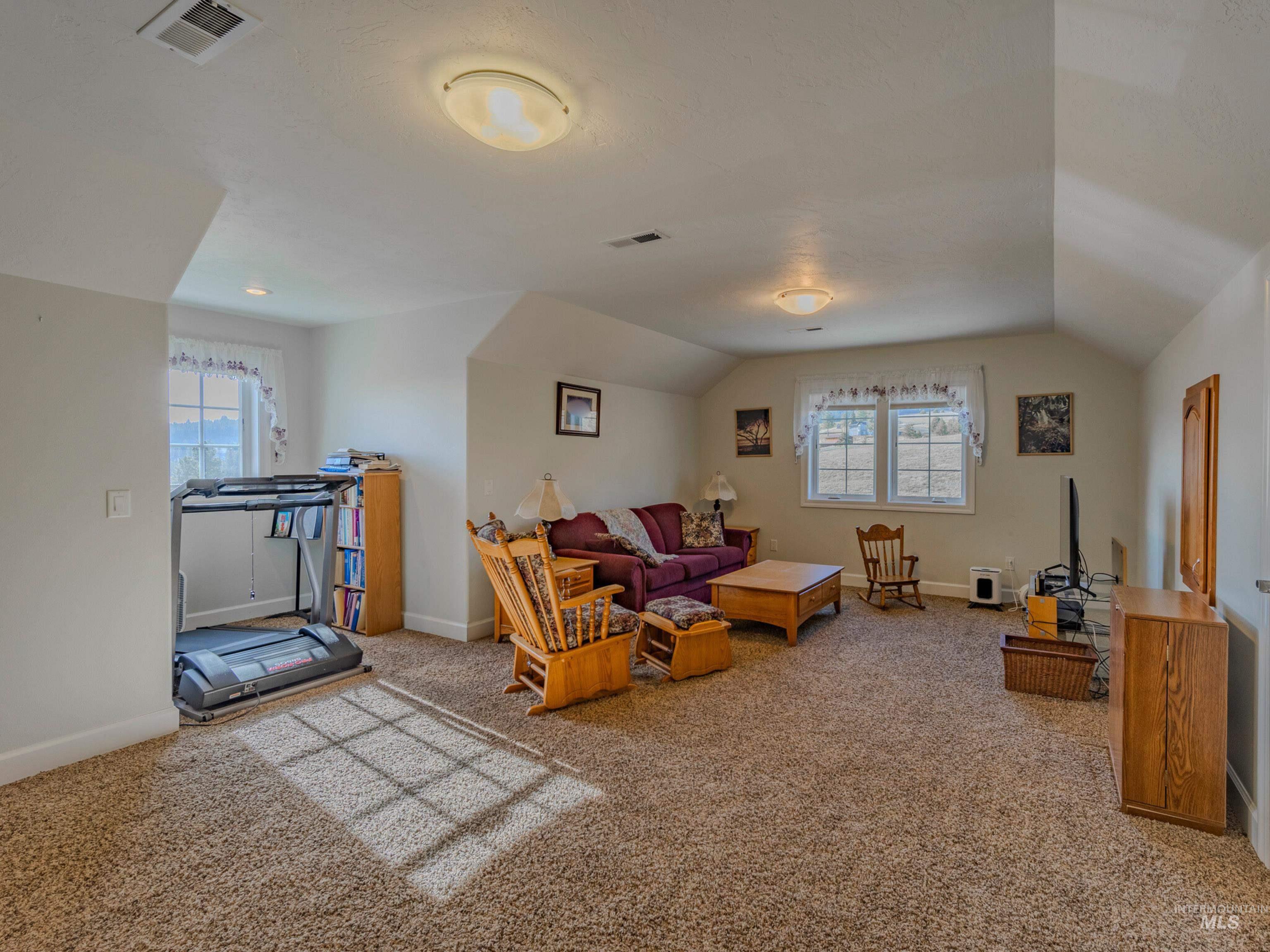 659 Reservation Line Road Cottonwood, ID 83522 - Photo 43 of 50 Living room featuring light carpet and vaulted ceiling