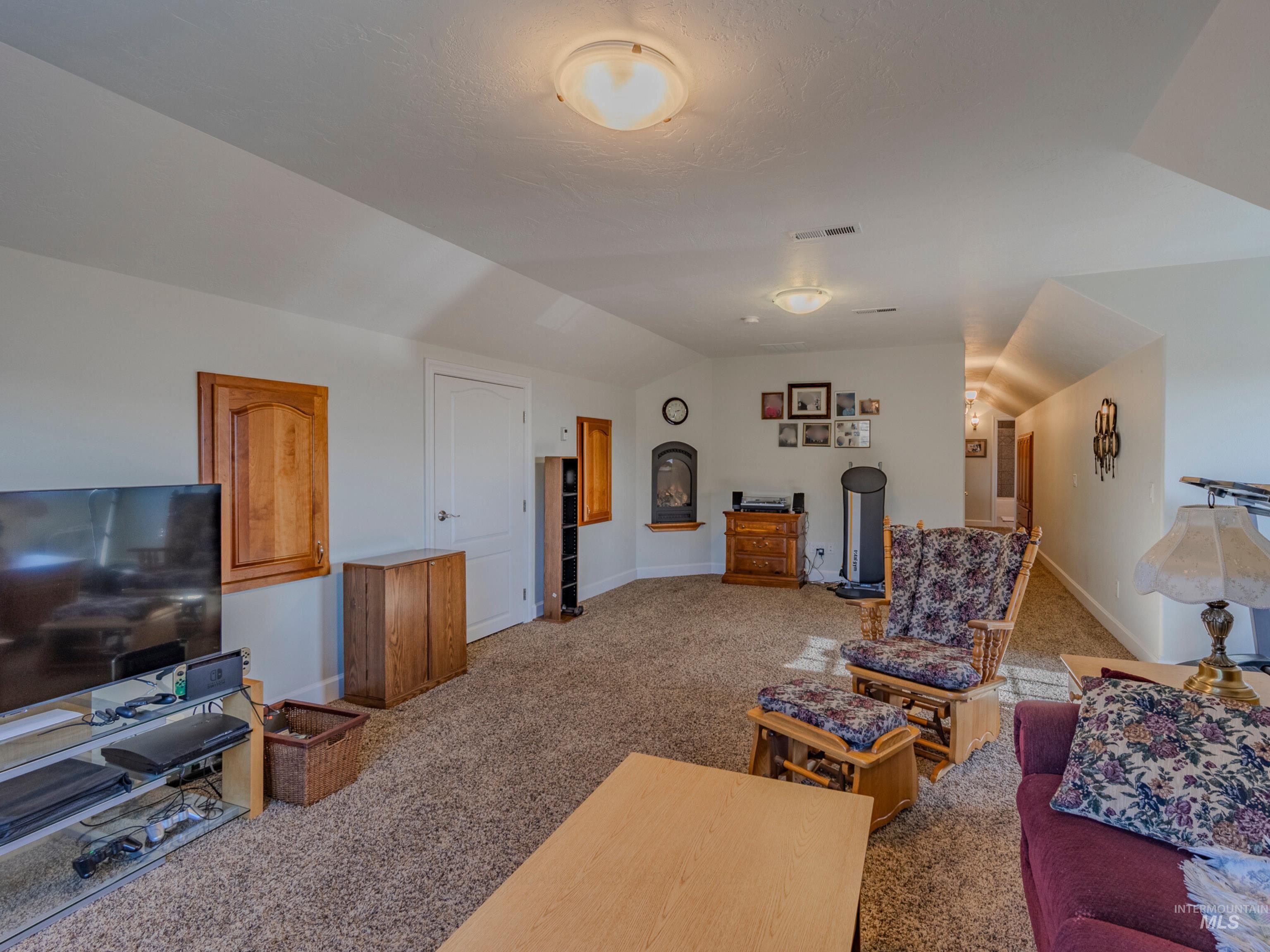 659 Reservation Line Road Cottonwood, ID 83522 - Photo 44 of 50 Living room with vaulted ceiling and dark colored carpet