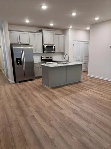 a kitchen with stainless steel appliances granite countertop a refrigerator sink and cabinets