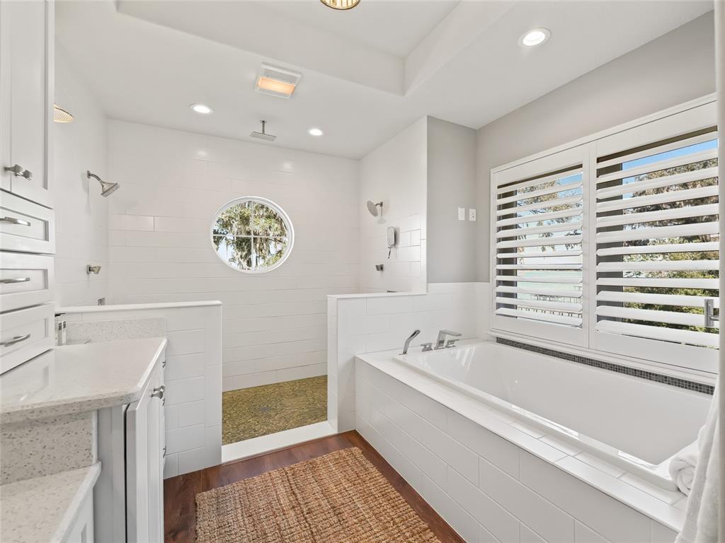 12943 Southeast Sunset Harbor Road Weirsdale, FL 32195 - Photo 33 of 87 a bathroom with a bathtub a sink and a window