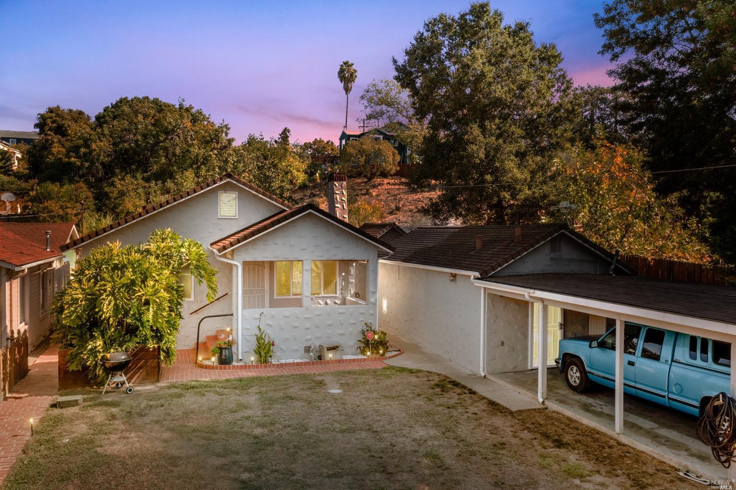 419 Vaqueros Avenue Rodeo, CA 94572 - Photo 1 of 1 a front view of a house with a yard and garage