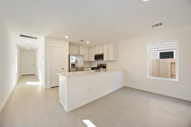 a view of a kitchen with refrigerator and windows