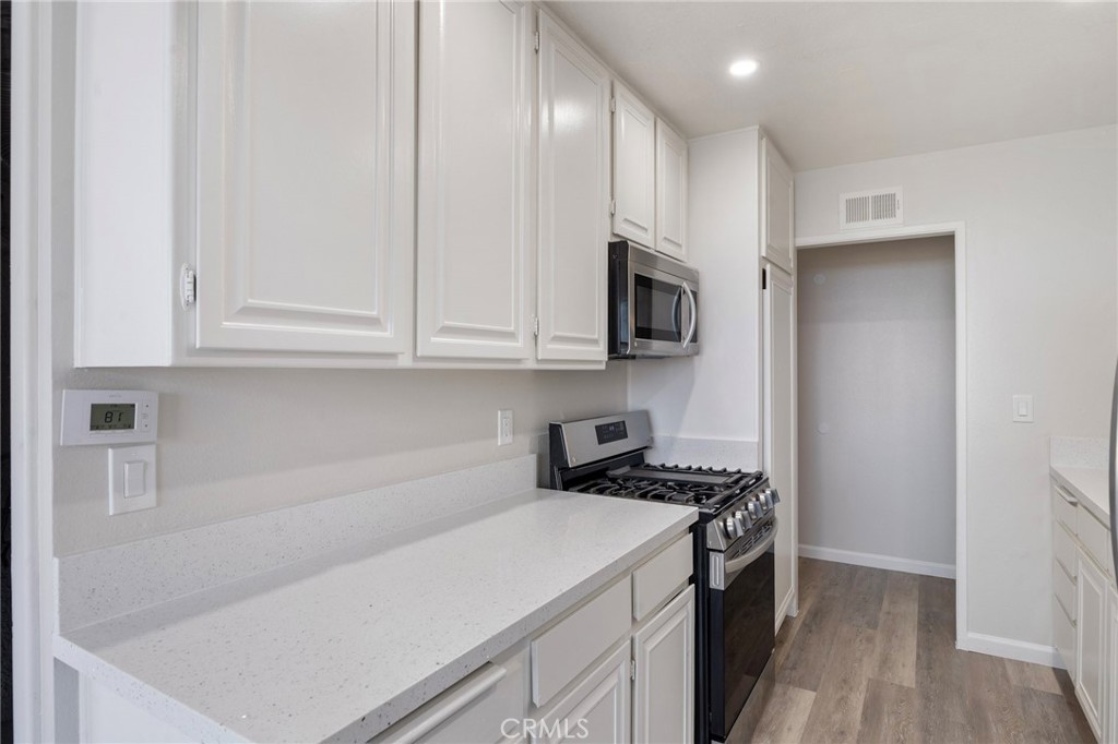 8737 Rhodes Court Santee, CA 92071 - Photo 6 of 30 a kitchen with cabinets appliances a sink and a counter top space