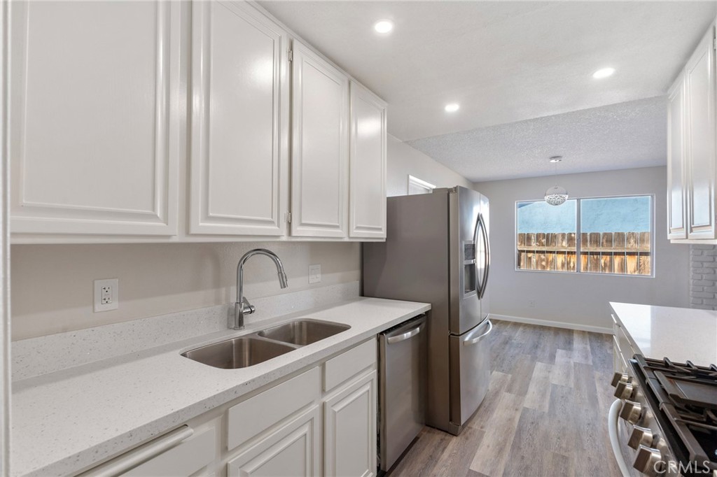 8737 Rhodes Court Santee, CA 92071 - Photo 8 of 30 a kitchen with stainless steel appliances granite countertop a sink a stove and a refrigerator