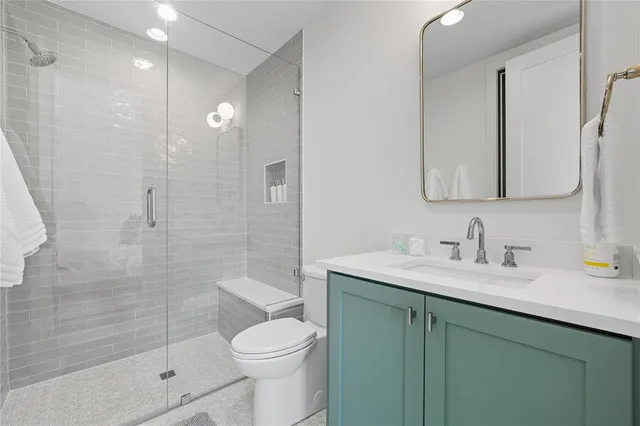 a bathroom with a sink a toilet and shower