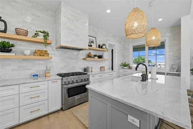 a kitchen with granite countertop a sink stainless steel appliances and cabinets