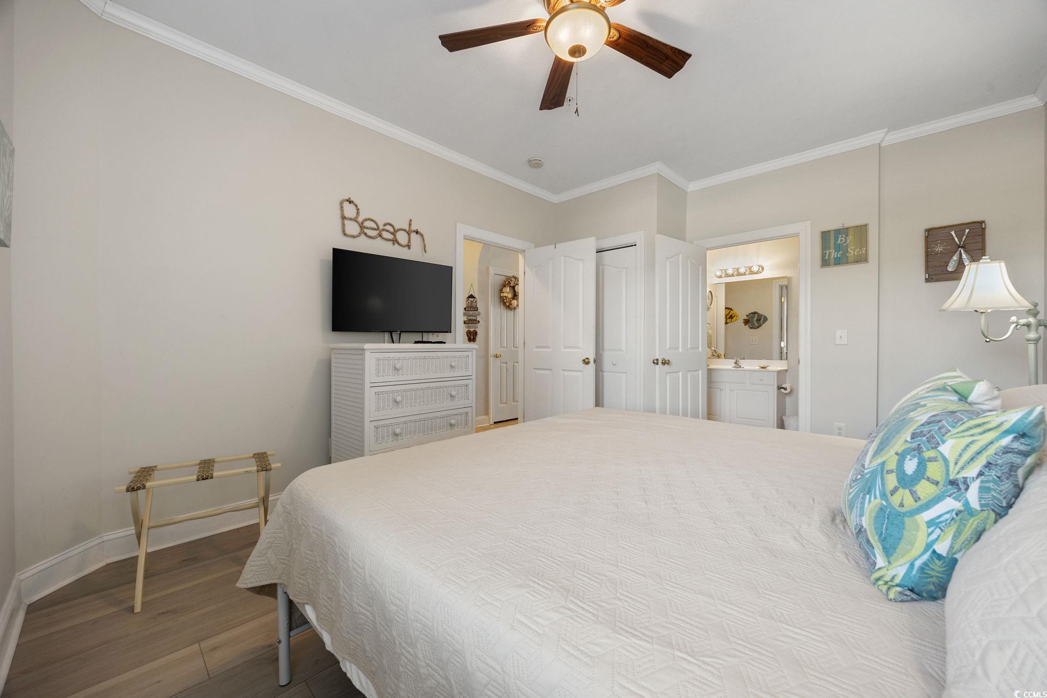 121 Waypoint Ridge Avenue, Unit P8 Little River, SC 29566 - Photo 20 of 40 Bedroom featuring ornamental molding, dark wood-style floors, ceiling fan, a closet, and connected bathroom