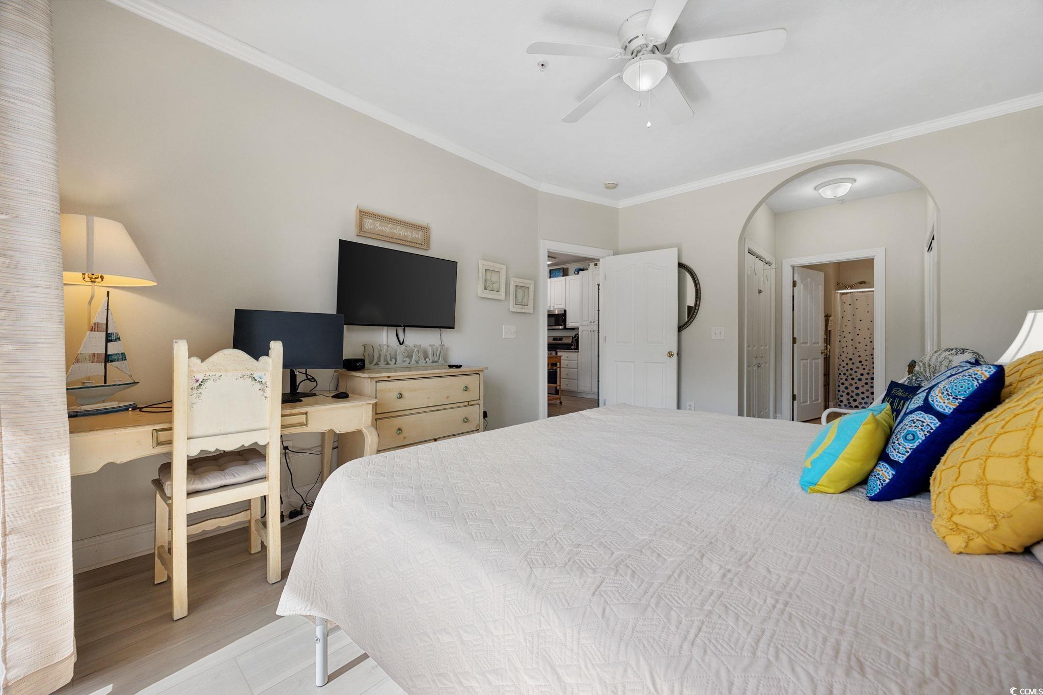 121 Waypoint Ridge Avenue, Unit P8 Little River, SC 29566 - Photo 26 of 40 Bedroom featuring ornamental molding, a ceiling fan, connected bathroom, arched walkways, and wood finished floors
