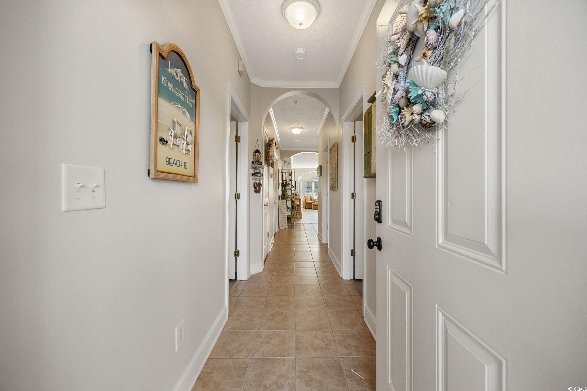 121 Waypoint Ridge Avenue, Unit P8 Little River, SC 29566 - Photo 3 of 40 Hall featuring arched walkways, light tile patterned flooring, and crown molding