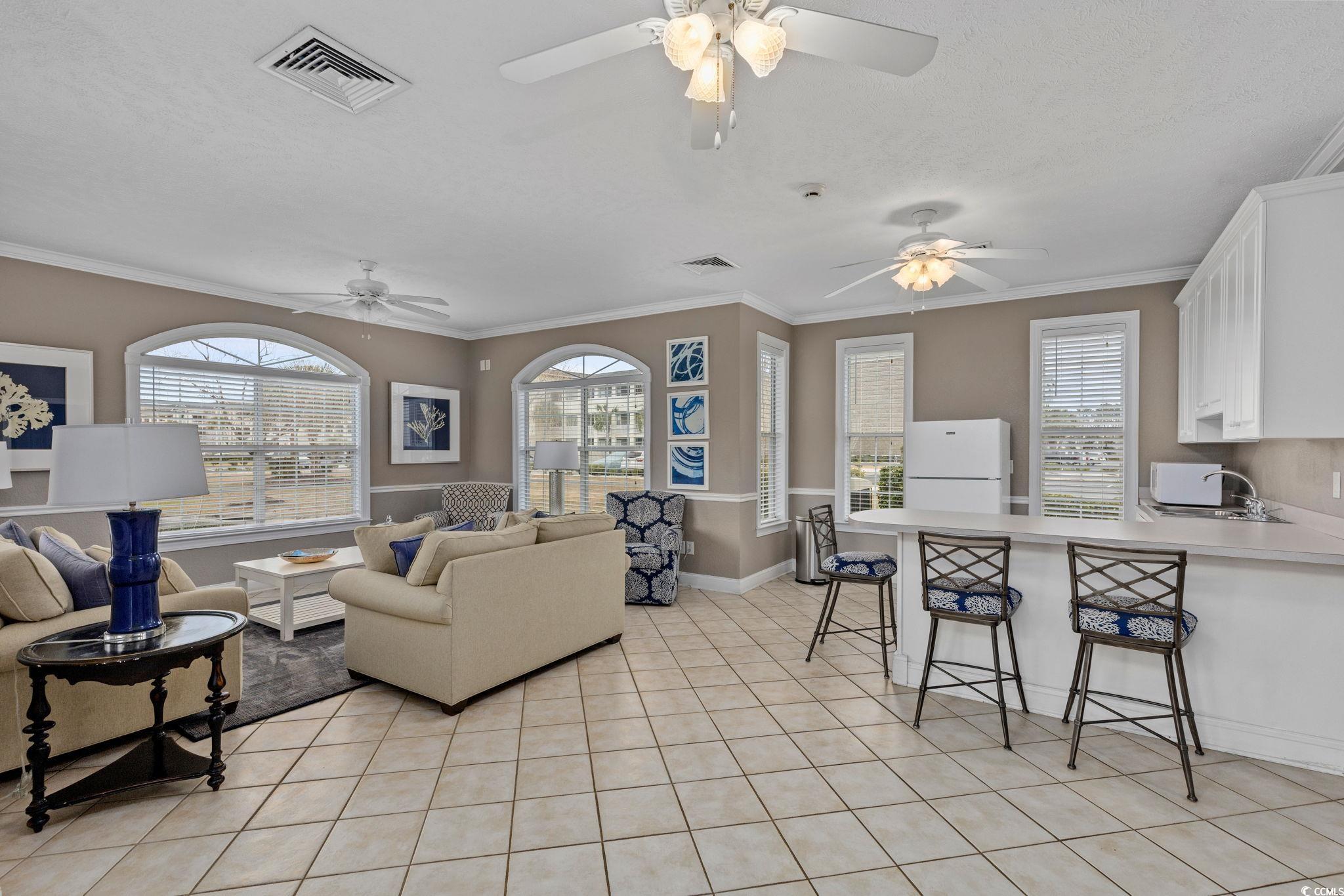 121 Waypoint Ridge Avenue, Unit P8 Little River, SC 29566 - Photo 34 of 40 Living room featuring ornamental molding, light tile patterned flooring, and a textured ceiling