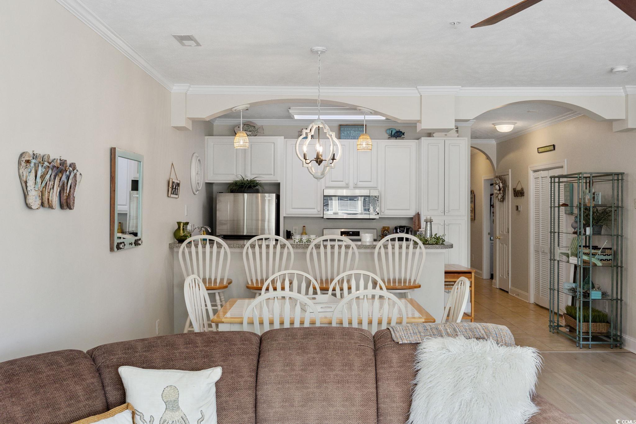 121 Waypoint Ridge Avenue, Unit P8 Little River, SC 29566 - Photo 8 of 40 Living room with ornamental molding, ceiling fan, light wood-type flooring, and a chandelier
