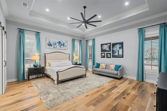 a bedroom with a large bed and a chandelier