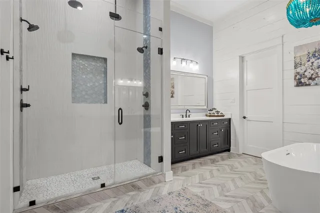a bathroom with a tub sink shower and mirror