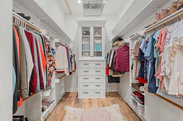 a view of walk in closet with clothes and shoes