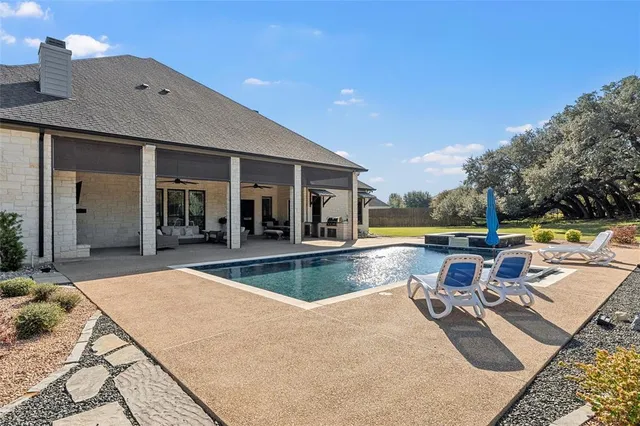 a view of a swimming pool with outdoor seating and plants