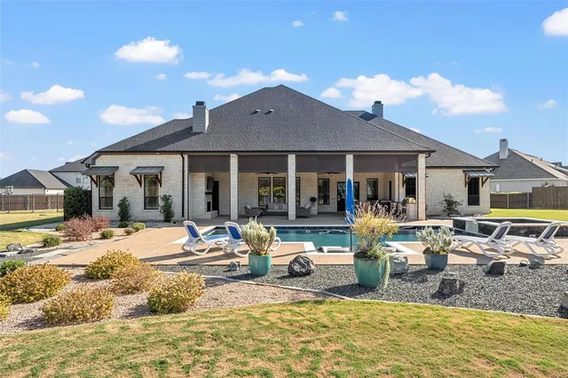 a view of a house with swimming pool and sitting area