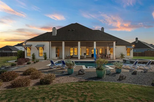 a view of a house with backyard water fountain and sitting area