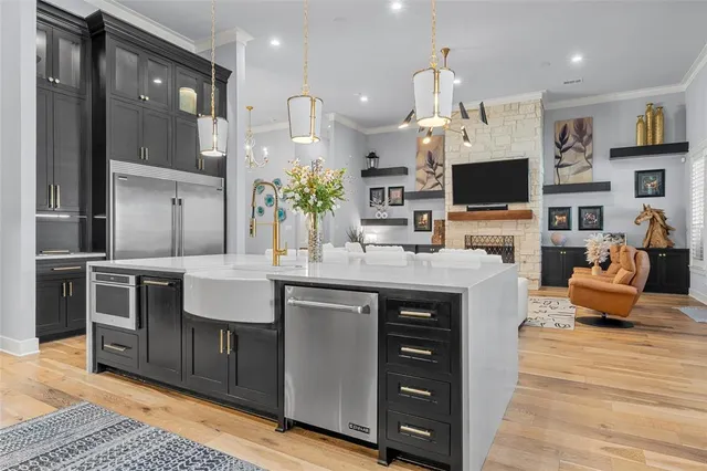 a kitchen with stainless steel appliances granite countertop a stove and a view of living room
