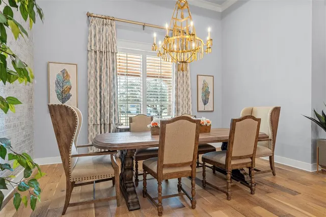 a view of a dining room with furniture a chandelier and wooden floor