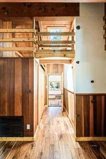 a view of a hallway with wooden floor and staircase