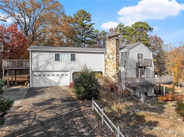 a view of a house with a yard and large trees