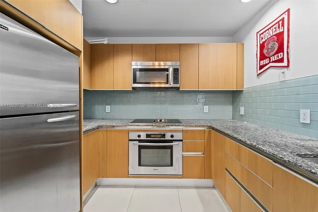 a kitchen with granite countertop a stove top oven microwave and cabinets