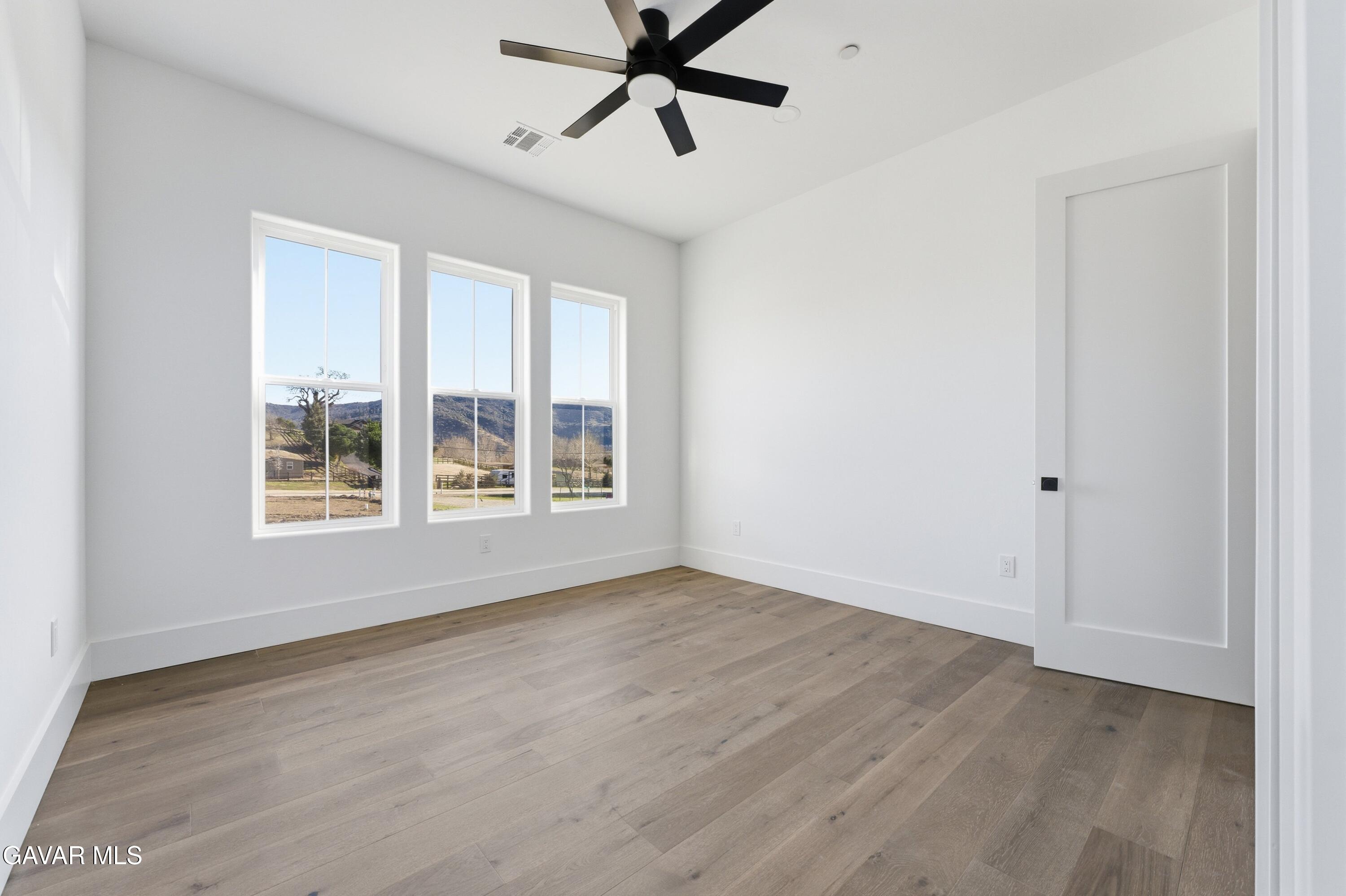 24401 Oaktree Court Tehachapi, CA 93561 - Photo 17 of 36 a view of an empty room with a window and wooden floor