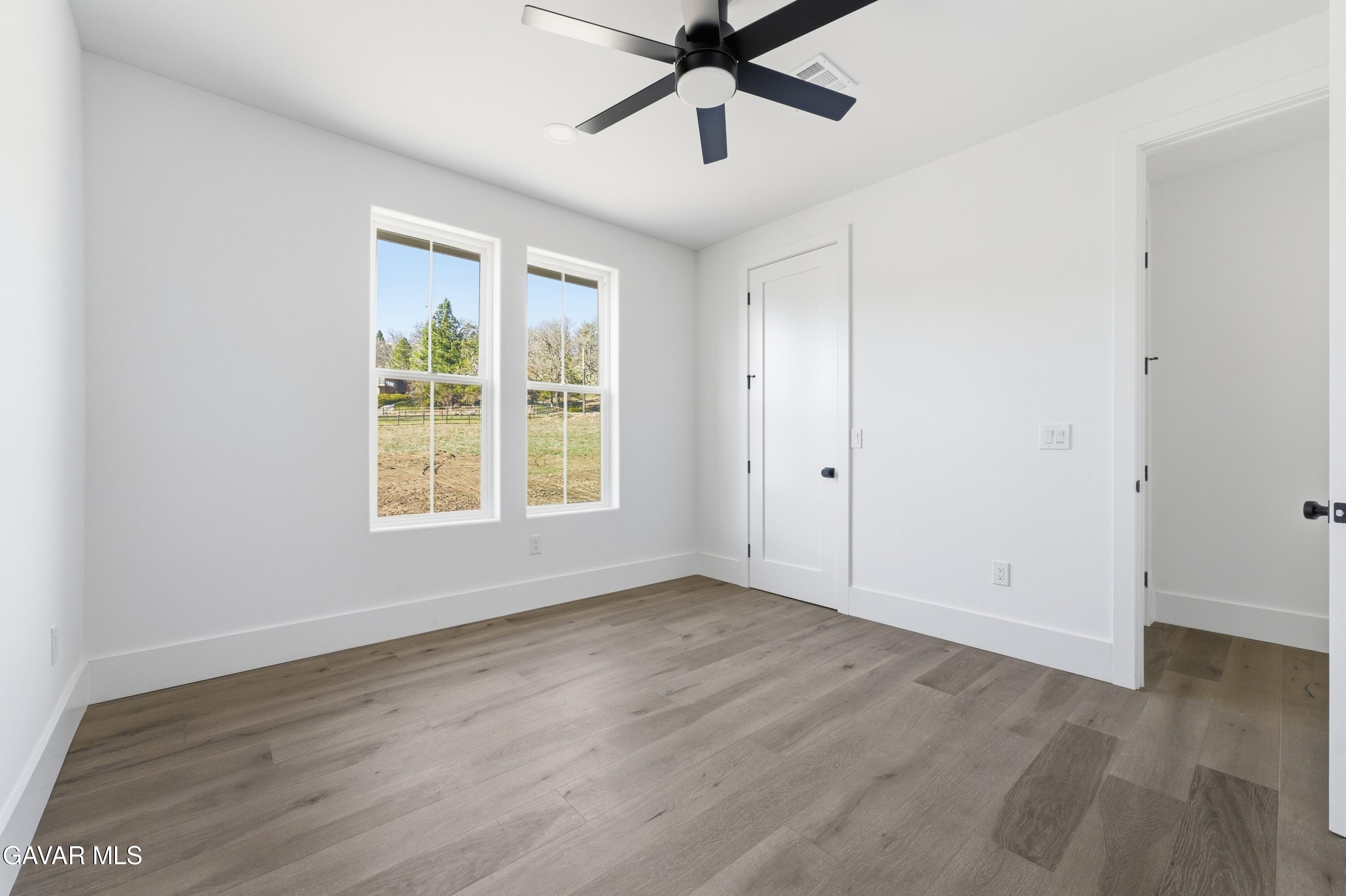 24401 Oaktree Court Tehachapi, CA 93561 - Photo 24 of 36 a view of an empty room with wooden floor and a window